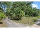 Long driveway leading to a gated entrance, surrounded by mature trees and landscaping offering privacy and curb appeal at 546 Winona Dr, Geneva, FL 32732