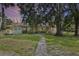 Charming single story home with a stone facade, mature trees, and a pathway leading to the entrance at 546 Winona Dr, Geneva, FL 32732