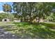 Charming home featuring a stone facade, mature trees, and a lush, green lawn at 546 Winona Dr, Geneva, FL 32732