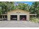 Detached garage with dual bays, open doors showing car and mower at 546 Winona Dr, Geneva, FL 32732