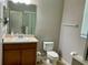 Bathroom featuring vanity, toilet, mirror and shower with glass door and tile flooring at 5917 Coquyt Dr, Mount Dora, FL 32757