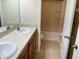 Bathroom featuring vanity with double sinks, toilet, bathtub, tile flooring and neutral colored walls at 5917 Coquyt Dr, Mount Dora, FL 32757