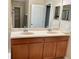 Bathroom featuring vanity with double sinks, mirror and neutral colored walls at 5917 Coquyt Dr, Mount Dora, FL 32757