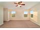 Neutral carpeted bedroom with two large windows, a ceiling fan, and a closet at 5917 Coquyt Dr, Mount Dora, FL 32757