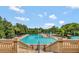Large community pool surrounded by lush landscaping with sun umbrellas and lounge chairs at 5917 Coquyt Dr, Mount Dora, FL 32757