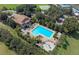 An aerial view of the large community pool, surrounded by palm trees and sun loungers at 5917 Coquyt Dr, Mount Dora, FL 32757
