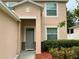 Inviting front entrance with a gray door and lush landscaping at 5917 Coquyt Dr, Mount Dora, FL 32757