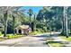 A guard house surrounded by lush landscaping stands at the entrance to a gated community at 5917 Coquyt Dr, Mount Dora, FL 32757