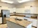 Kitchen with an island, stainless steel appliances, and white cabinetry at 5917 Coquyt Dr, Mount Dora, FL 32757