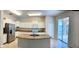 Well-lit kitchen features an island, stainless steel refrigerator, and sliding glass doors to the patio at 5917 Coquyt Dr, Mount Dora, FL 32757