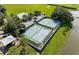 Aerial view of four well-maintained tennis courts and a basketball court nestled within green landscaping at 5917 Coquyt Dr, Mount Dora, FL 32757