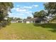 Large, grassy backyard with mature trees surrounding the property, offering a private retreat at 5990 Se 5Th Pl, Ocala, FL 34472