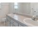 Bathroom with a dual sink vanity, white cabinets, a large mirror, and a window at 5990 Se 5Th Pl, Ocala, FL 34472