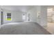 Open floor plan with new carpeting, windows providing natural light, and a view of the kitchen at 5990 Se 5Th Pl, Ocala, FL 34472