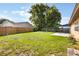 Spacious backyard showcasing a lush lawn, privacy fence, and a concrete patio area at 6835 Massa Ct, Orlando, FL 32810