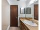 Bathroom features a wood vanity, white sink, and mirrors, with tile flooring and a walk-in shower at 6835 Massa Ct, Orlando, FL 32810