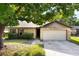 Charming single-story home with a stone facade, two-car garage, and mature tree in the front yard at 6835 Massa Ct, Orlando, FL 32810