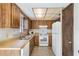 Functional kitchen with wood cabinets, tile flooring, and a double stainless steel sink at 6835 Massa Ct, Orlando, FL 32810