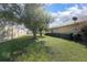 Spacious, grassy backyard surrounded by lush shrubbery, mature trees and a fenced in border at 710 Independence Dr, Orange City, FL 32763