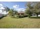 Grassy backyard with mature trees and landscaping, with a view of the house and the neighborhood at 710 Independence Dr, Orange City, FL 32763