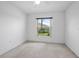 This bright bedroom has neutral carpet and a window overlooking a well-maintained backyard at 710 Independence Dr, Orange City, FL 32763