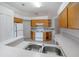 Functional kitchen with oak cabinets, white appliances, and tiled floors, offering ample counter space at 710 Independence Dr, Orange City, FL 32763