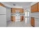 Bright kitchen with oak cabinets, tile flooring, and white appliances offers lots of storage and natural light at 710 Independence Dr, Orange City, FL 32763