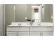 Modern bathroom boasts a double vanity with sleek countertops and a large mirror, perfect for a luxurious feel at 7374 Ivy Tendril Ave, Orlando, FL 32829