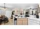 Bright kitchen with a double sink, white cabinets, and an adjacent dining area with a Christmas tree at 829 Camargo Way # 211, Altamonte Springs, FL 32714
