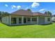 View of house exterior with backyard, covered patio, and lush green lawn at 10 Dial Ave, Debary, FL 32713