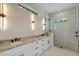 Elegant bathroom featuring double sinks, a frameless glass shower, and modern sconce lighting at 10 Dial Ave, Debary, FL 32713