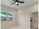 Bright bedroom with tile floors and large windows, with view into ensuite bathroom at 10 Dial Ave, Debary, FL 32713
