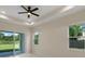 This bedroom boasts a tray ceiling, ceiling fan, and sliding glass doors to the outdoors at 10 Dial Ave, Debary, FL 32713
