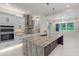 Modern kitchen features an island with a waterfall countertop and sleek white cabinetry at 10 Dial Ave, Debary, FL 32713