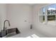 Well-lit laundry room with stainless steel sink, tile floor, and ample natural light at 10 Dial Ave, Debary, FL 32713