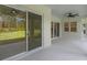 Covered patio with view of the backyard through large glass sliding doors and windows at 10 Dial Ave, Debary, FL 32713