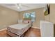 This cozy bedroom features hardwood floors, a ceiling fan, and a bright window overlooking the yard at 1090 Sonoma Ct, Longwood, FL 32750