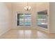 Bright dining area with tile floors, windows overlooking a screened pool, and a modern chandelier at 1154 Feather Dr, Deltona, FL 32725