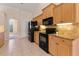 Well-lit kitchen featuring light wood cabinets, granite countertops, and modern black appliances at 1154 Feather Dr, Deltona, FL 32725