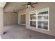 Covered back patio with ceiling fans and an exterior door to the landscaped backyard and screened-in pool at 1154 Feather Dr, Deltona, FL 32725