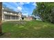 Expansive backyard featuring a screened in porch, a lush lawn, and mature trees at 1225 Hollow Pine Dr, Oviedo, FL 32765