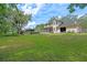 Expansive backyard featuring a screened in porch, a lush lawn, and mature trees at 1225 Hollow Pine Dr, Oviedo, FL 32765