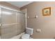 Bathroom featuring a shower/tub combo with sliding glass doors and a toilet with tan walls at 1225 Hollow Pine Dr, Oviedo, FL 32765