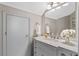 Bathroom featuring modern vanity, decorative mirror, and white floral accents at 1225 Hollow Pine Dr, Oviedo, FL 32765