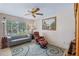 Cozy bedroom with a comfortable chair, a large window, and a ceiling fan at 1225 Hollow Pine Dr, Oviedo, FL 32765