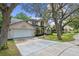 Charming two-story home featuring a well-manicured lawn, mature trees, and an attached two-car garage at 1225 Hollow Pine Dr, Oviedo, FL 32765