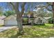 Charming home featuring a well-maintained lawn, mature trees, and a two-car garage, complete with inviting curb appeal at 1225 Hollow Pine Dr, Oviedo, FL 32765