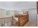 Second-floor hallway with a wood railing and a view to the front yard through a large arched window at 1225 Hollow Pine Dr, Oviedo, FL 32765