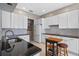 Modern kitchen featuring white cabinets, sleek black countertops, stainless steel appliances, and stylish backsplash tiles at 1225 Hollow Pine Dr, Oviedo, FL 32765