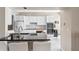 Modern kitchen with white cabinets, black countertops, stainless steel appliances, and breakfast bar at 1225 Hollow Pine Dr, Oviedo, FL 32765